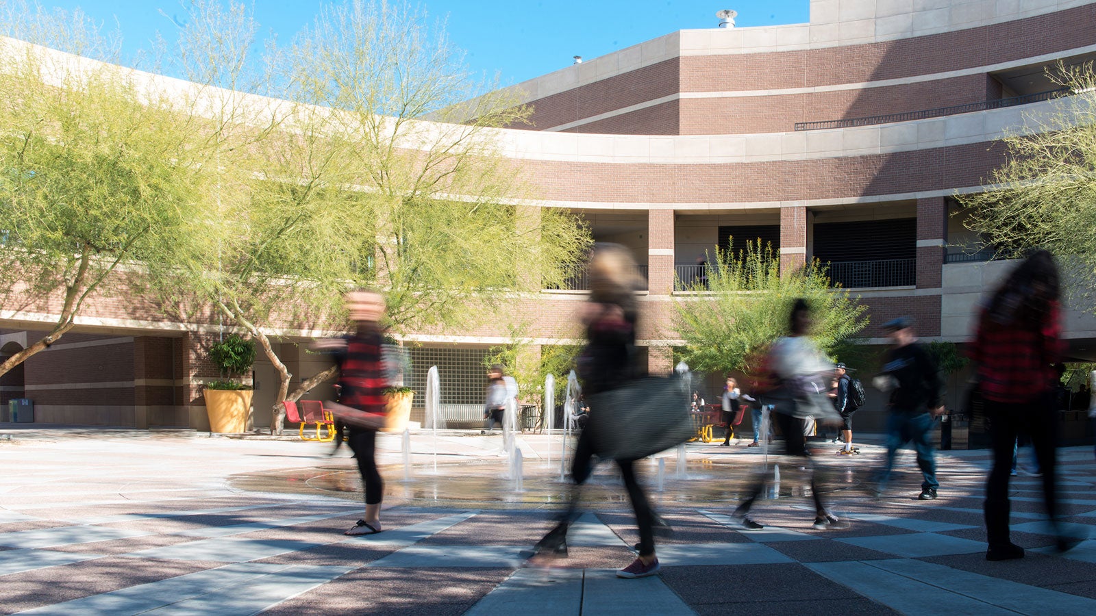 People walk through a college courtyard