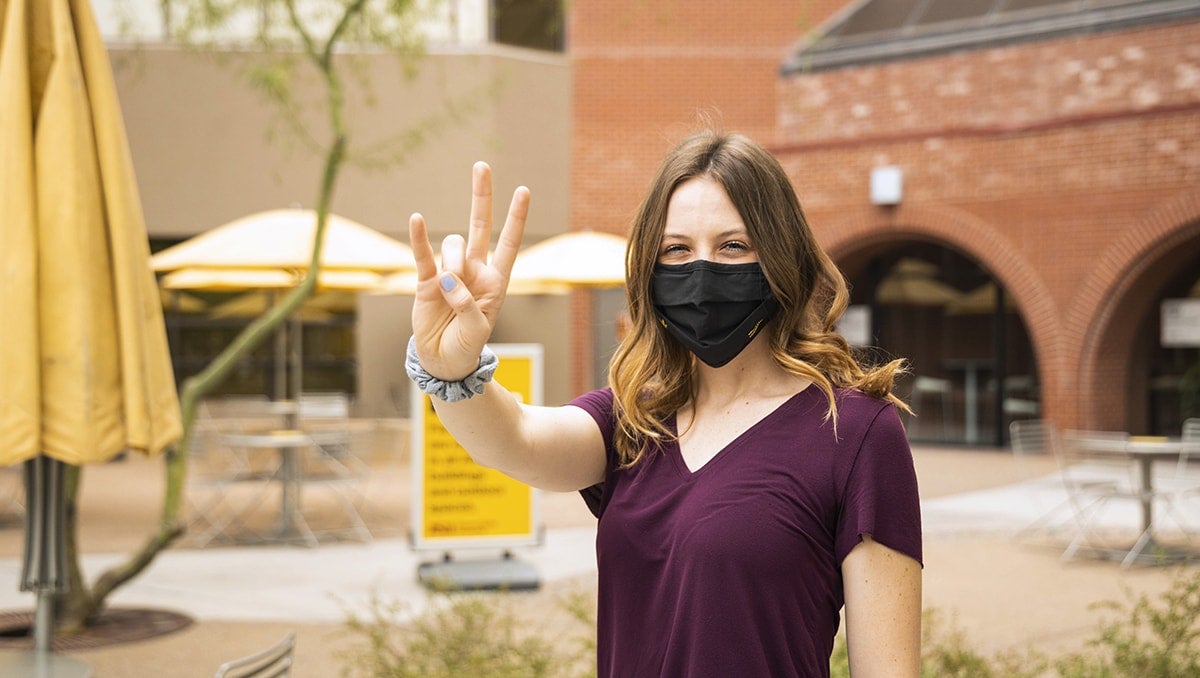 Student outdoors with face covering