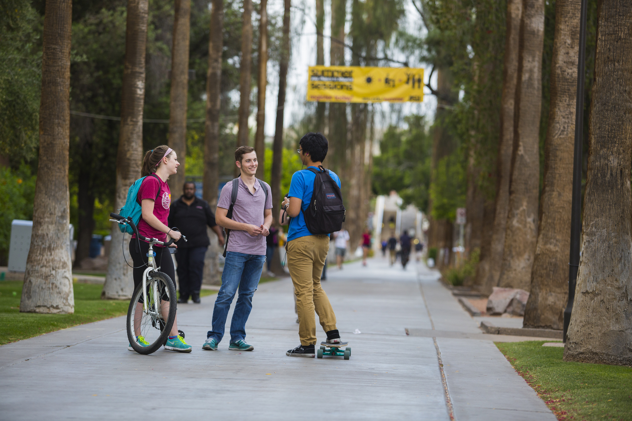 ASU students talking along sidewalk and palm trees