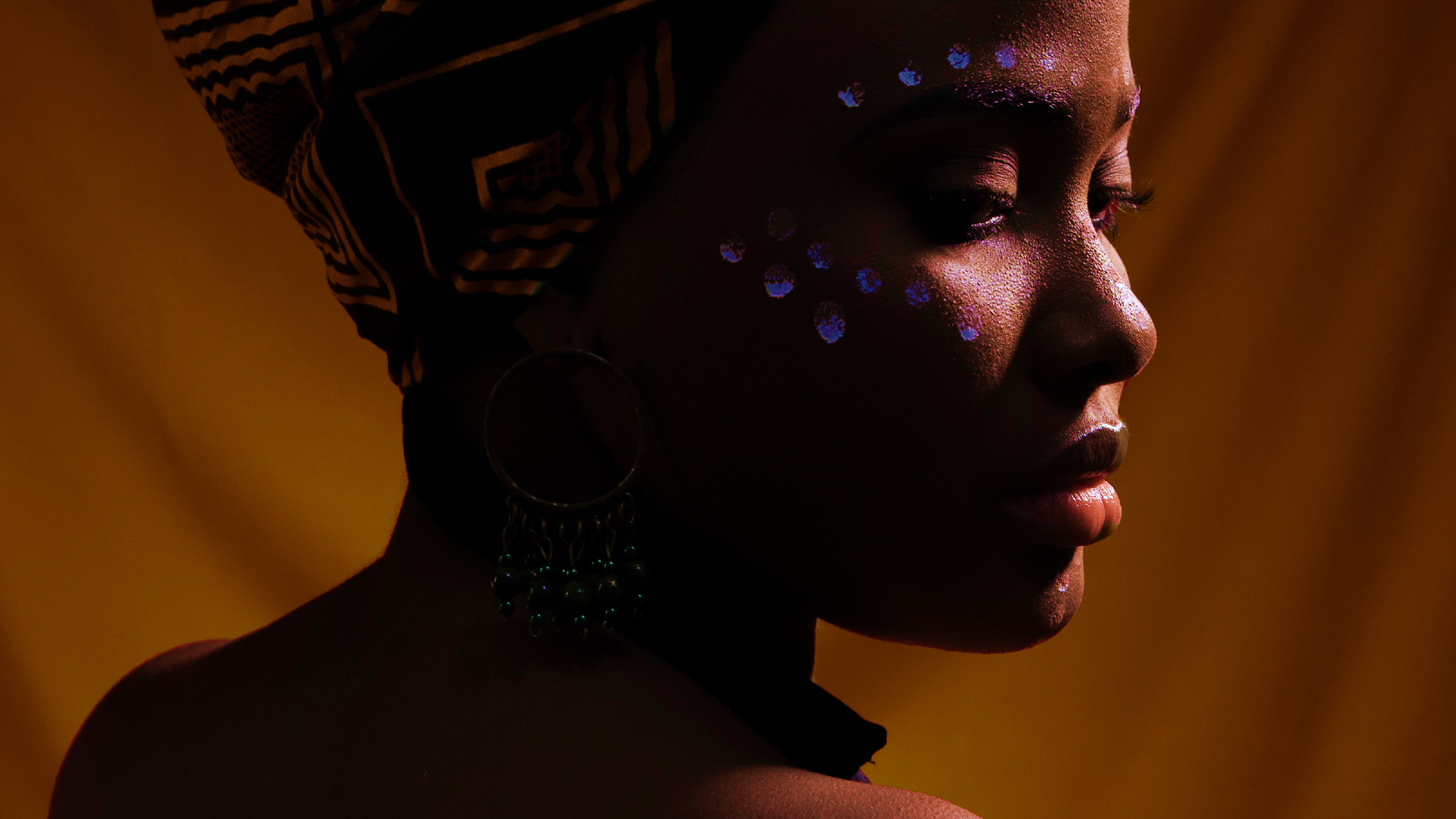 African American woman with glowing markings around her eye.