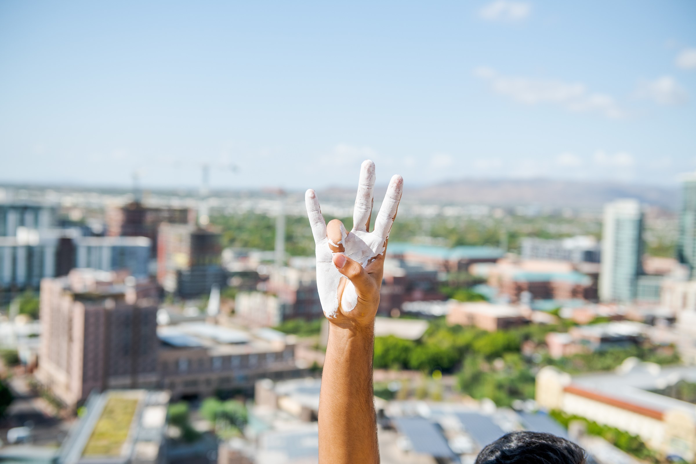 A painted hand makes the pitchfork salute at ASU's 2019 "Echo from the Buttes" event / Photo by Jared Opperman/ASU