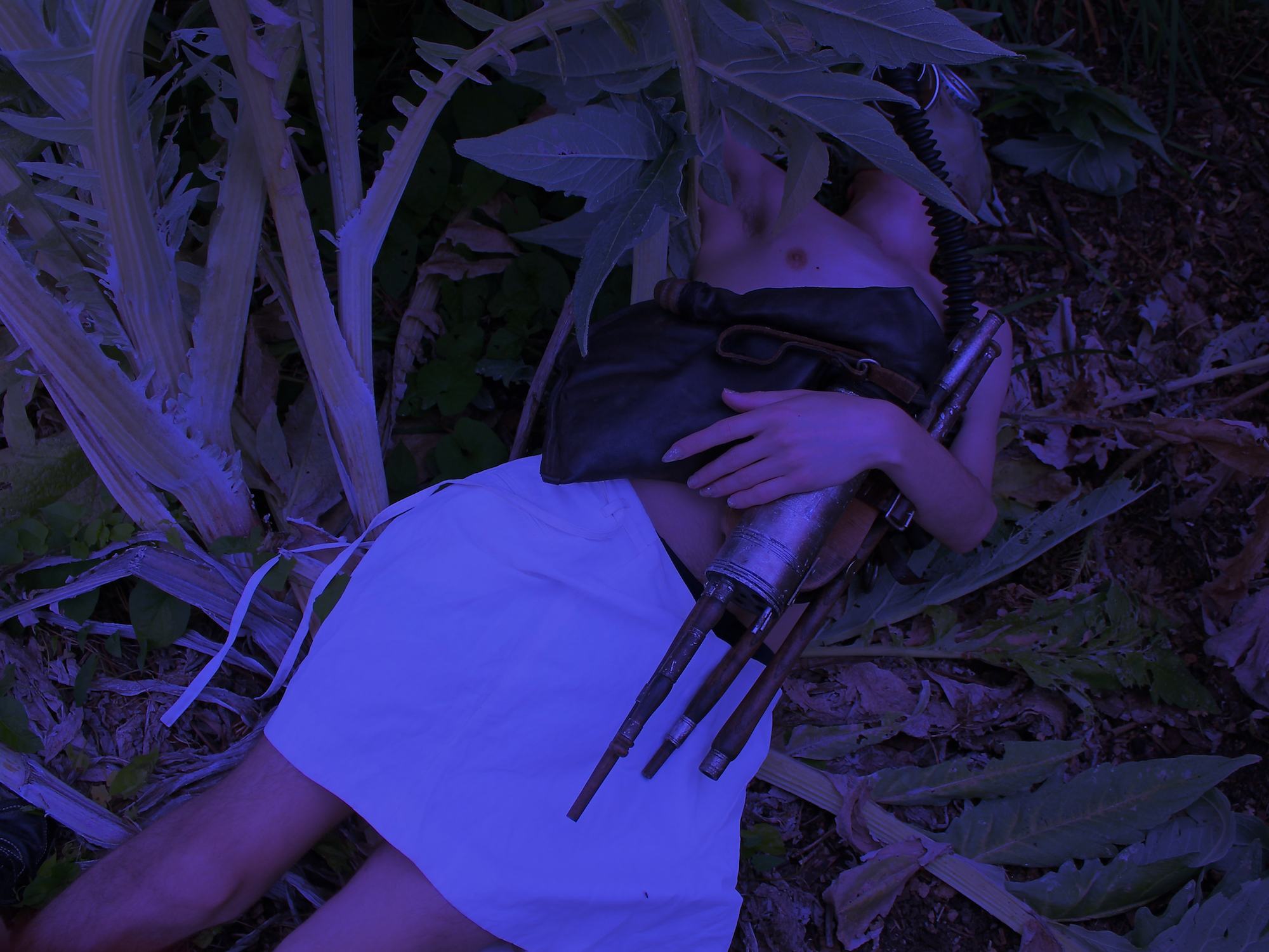 An animatronic doll lies in the grass in this artwork by felicita of PC Music