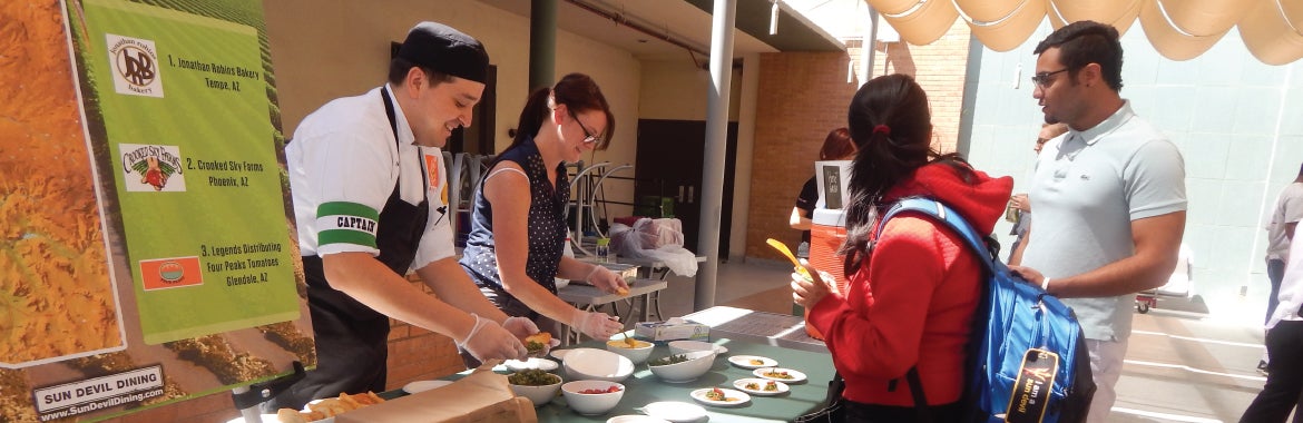 people scooping food samples to students