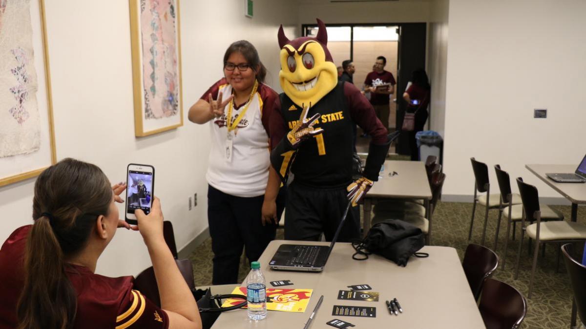 future female student posing for a selfie with Sparky the Sun Devil