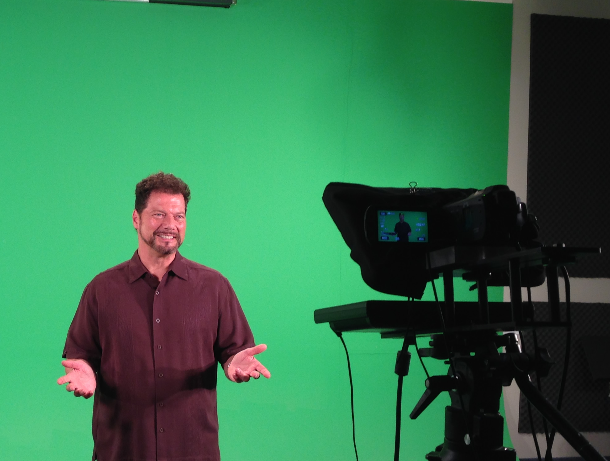 Photo of Gene Ganssle acting in front of a green screen.