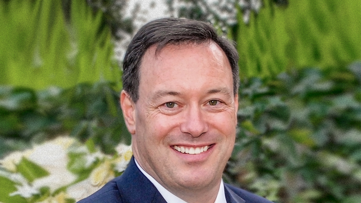 headshot photo of professional male in blue suit
