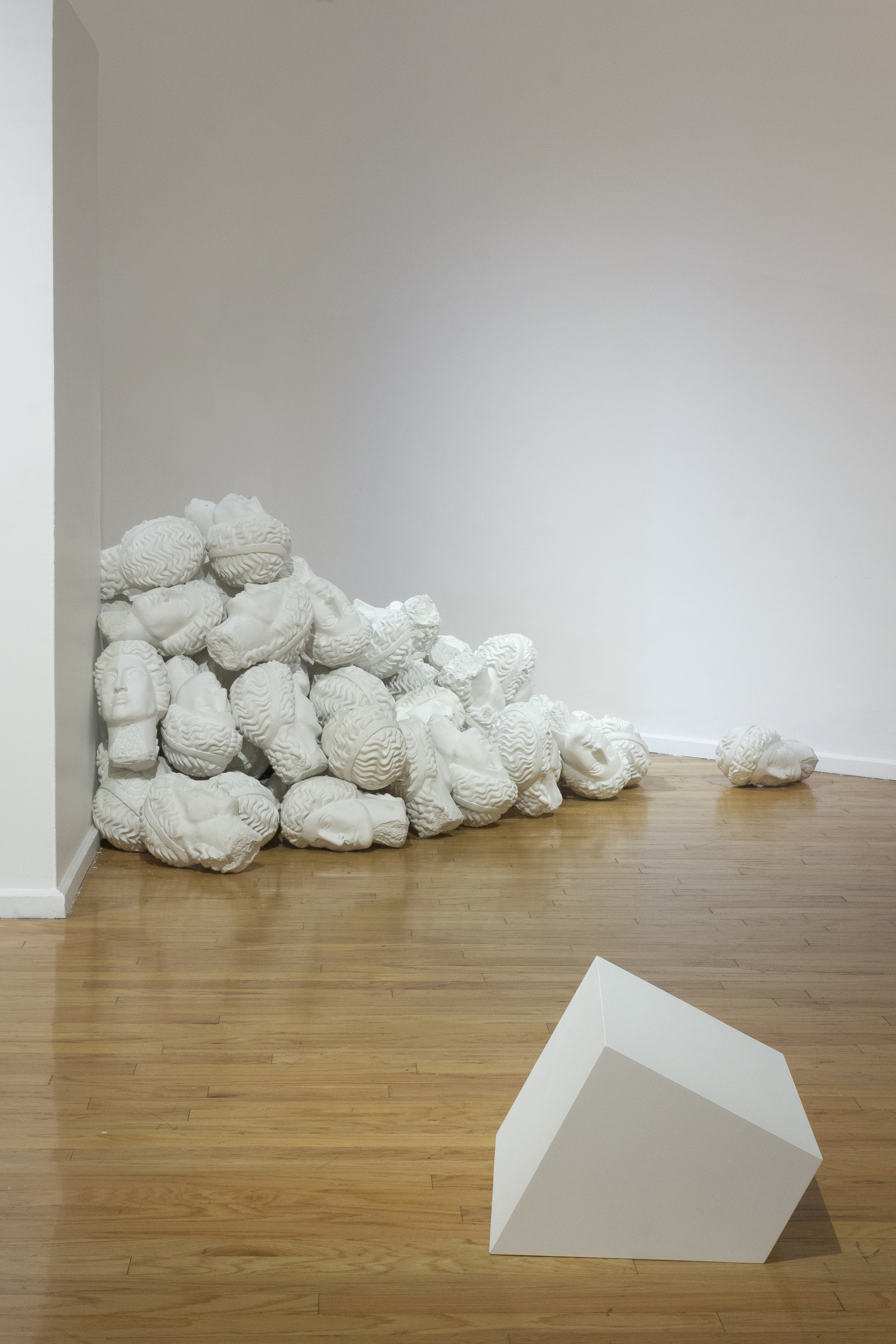 A pile of sculptural heads lies in a corner in the exhibition curated by Paulina Ascencio