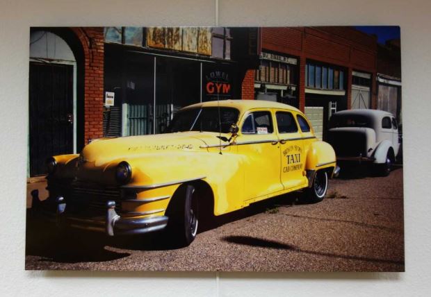 photo of an old fashioned taxi cab parked on the street