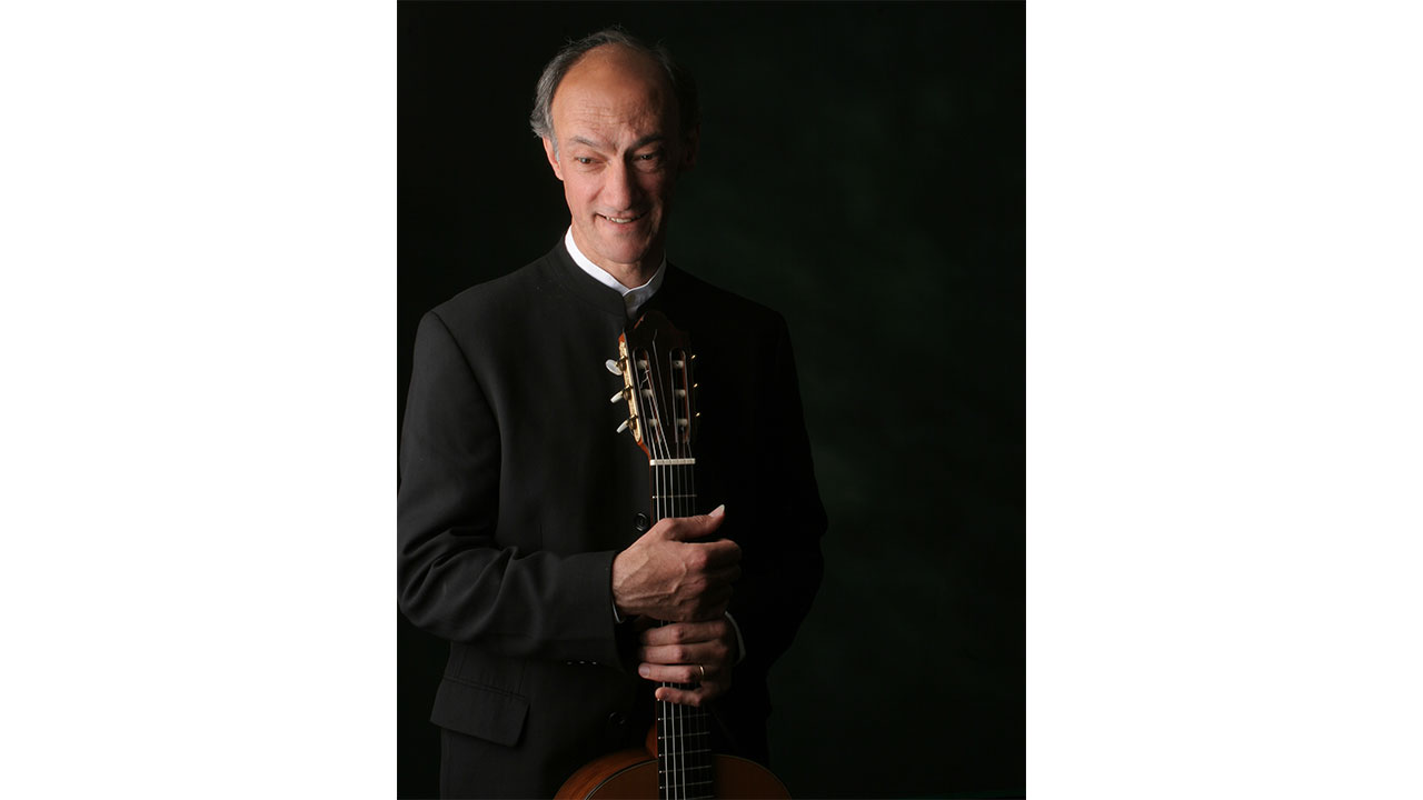 Photo of Roberto Aussel holding a guitar