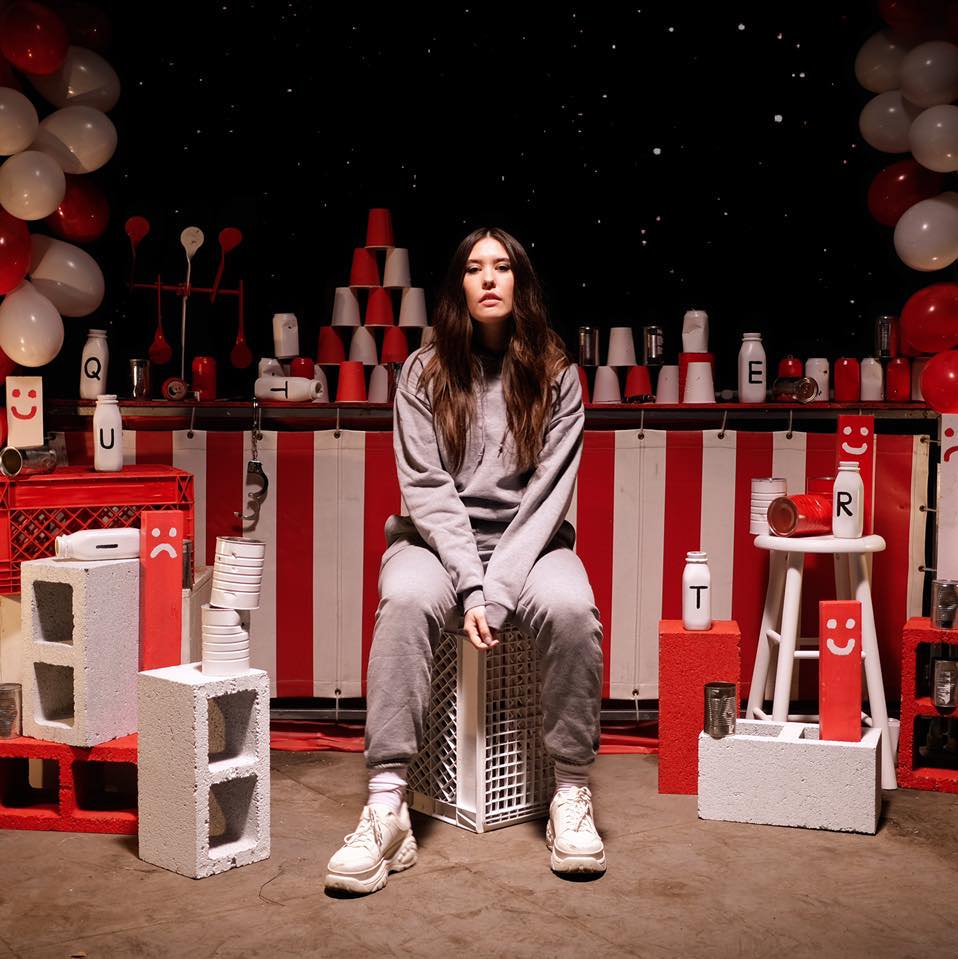 Sydney Sprague sits in a room of red cups, red and white banners