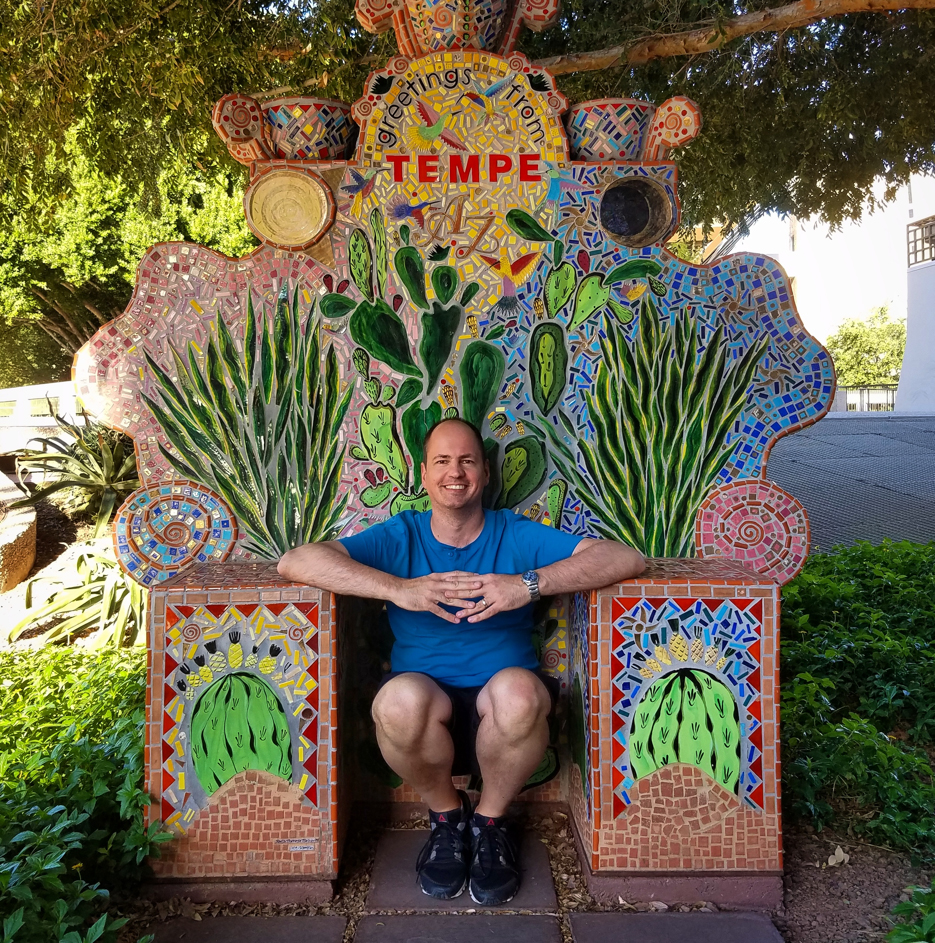 Courtesy image of linguist Vedran Dronjic sitting in a colorful, mosaic chair