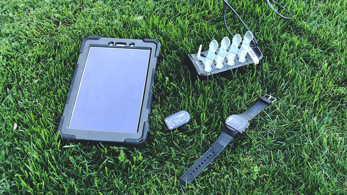 Tablet watch and devices on grass