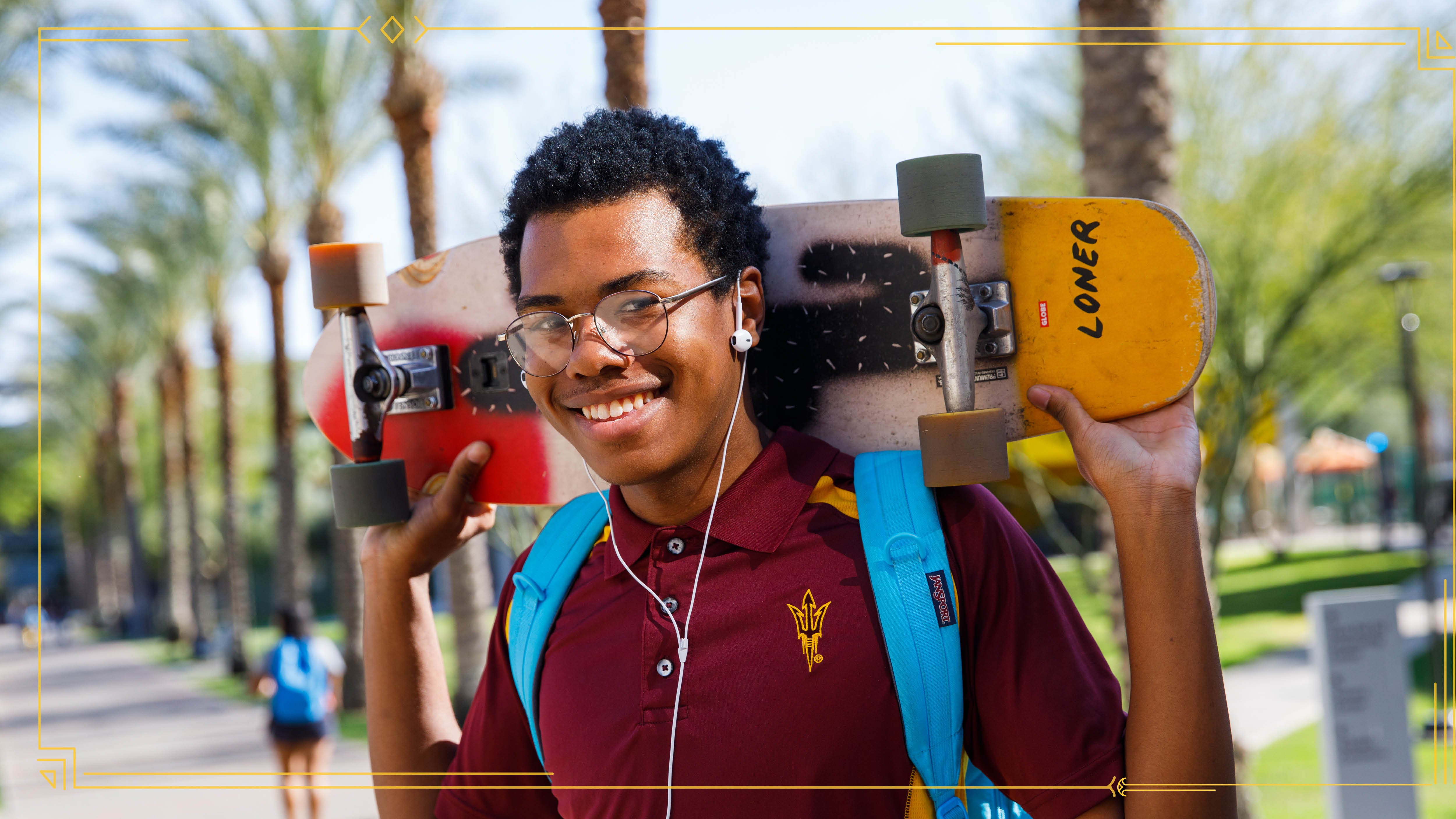Confident ASU student holding skateboard behind his head.