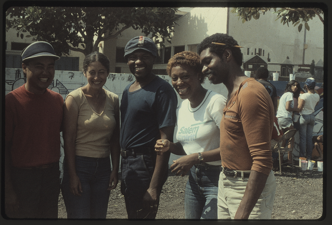 Five students, representing a mix of genders and ethnicities laughing and smiling, taken during the 1970s