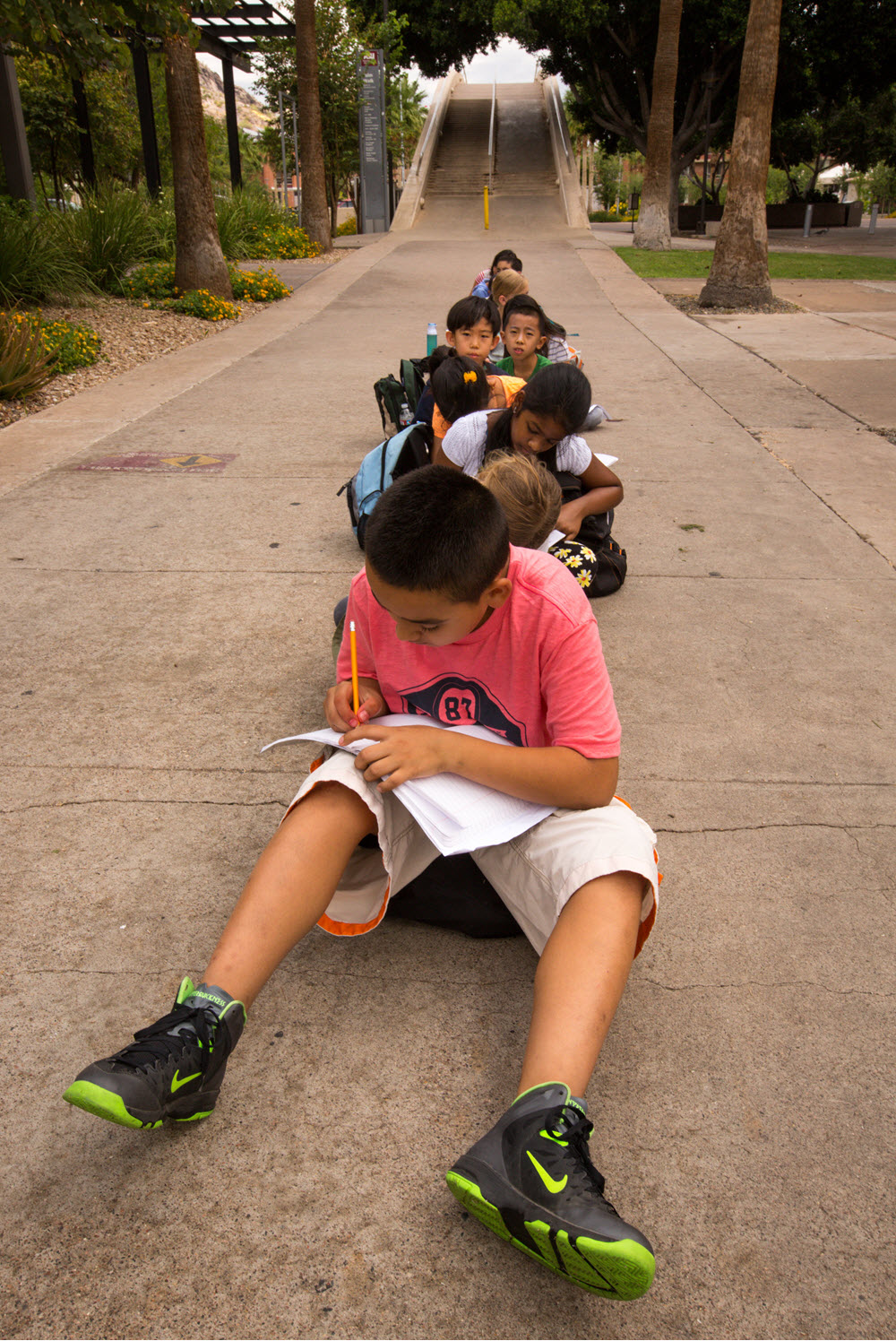 Image of young people writing in their journals on the ASU campus / Photo by Charlie Leight/ASU