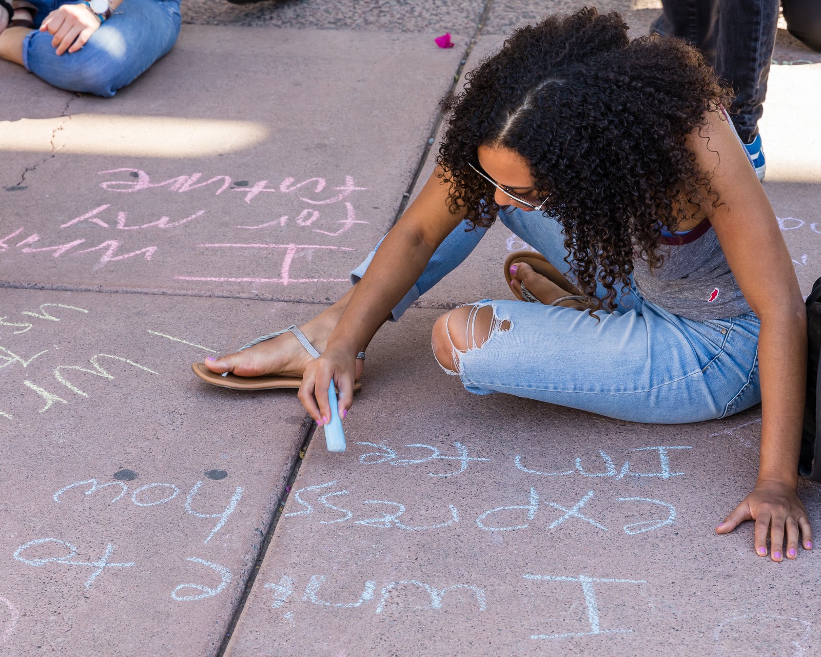 A person writes with sidewalk chalk at the 2019 celebration of National Day on Writing at ASU / Photo by Bruce Matsunaga