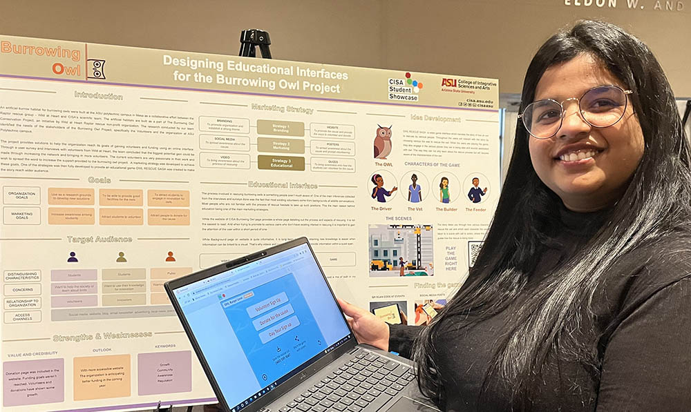 student researcher stands near poster displayed at spring 2021 CISA Student Showcase