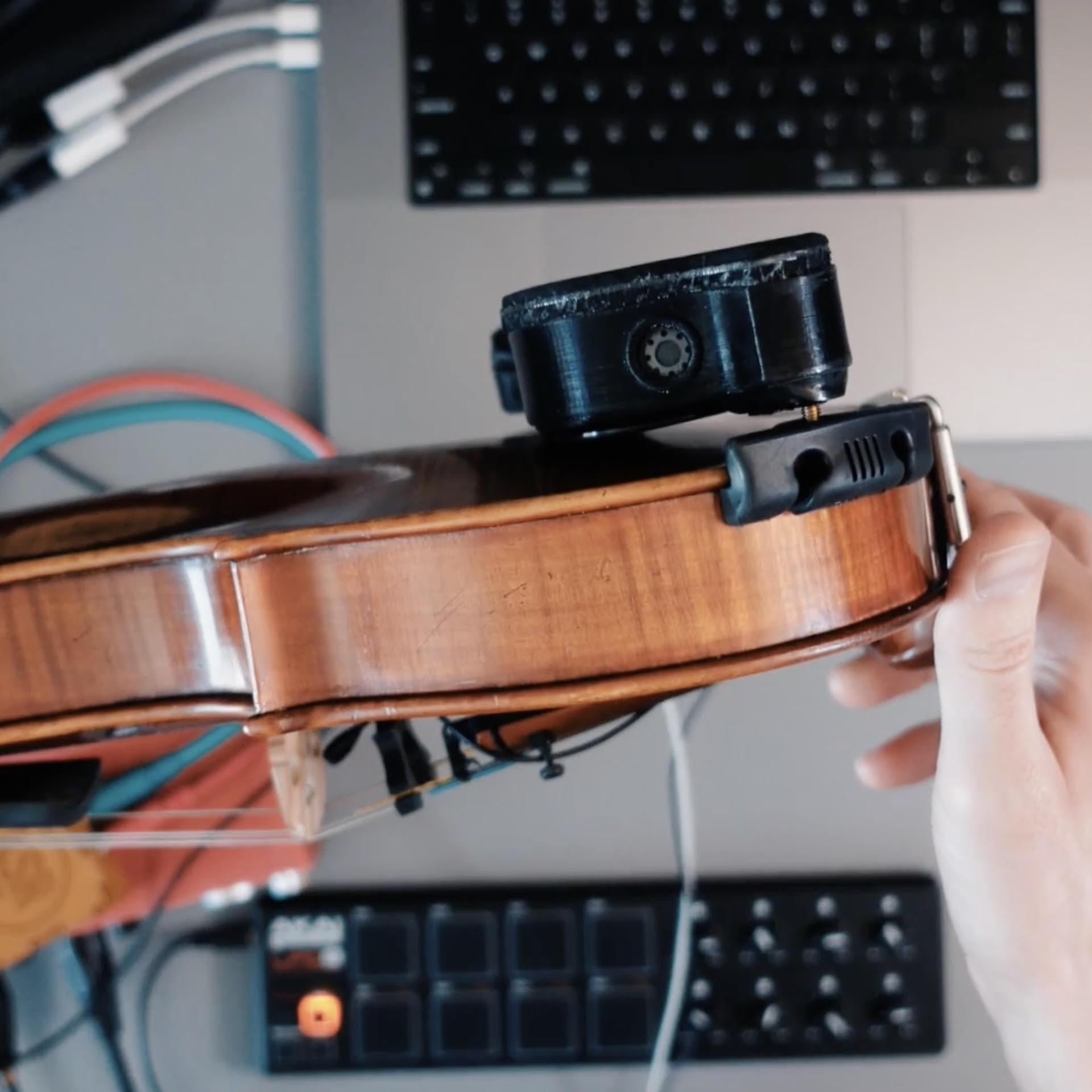 Violin with electronics attached to it.