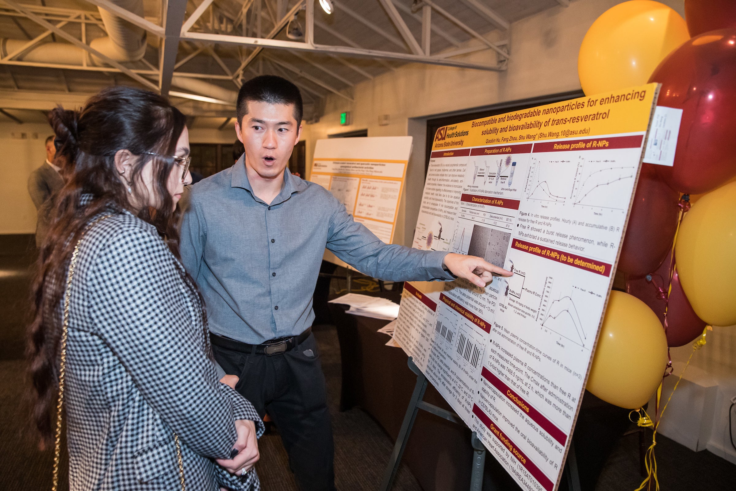 A faculty member explains his research to an interested person.