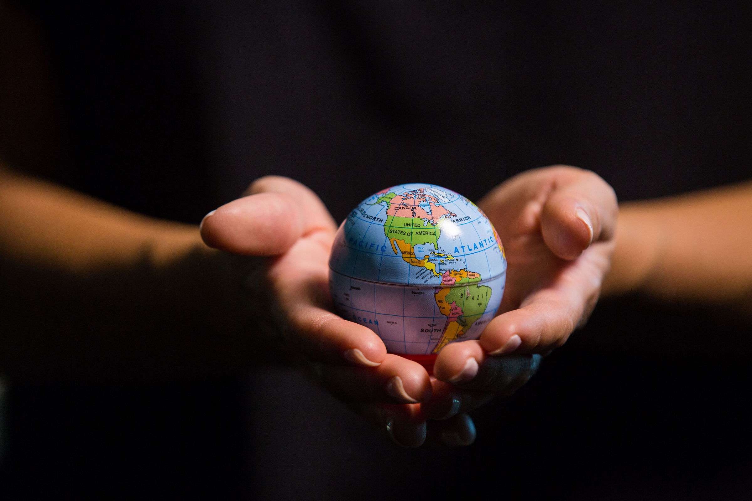hands holding tiny globe